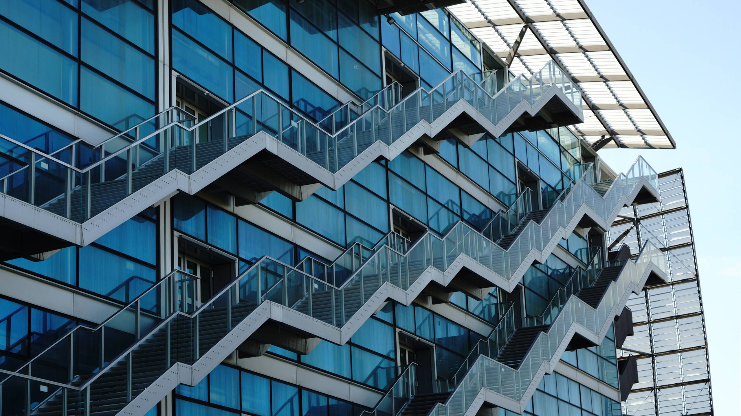 Лестница в небоскребе. Лестница на фасаде здания. Лестница снаружи здания. Наружная лестница. Красная металлическая лестница.